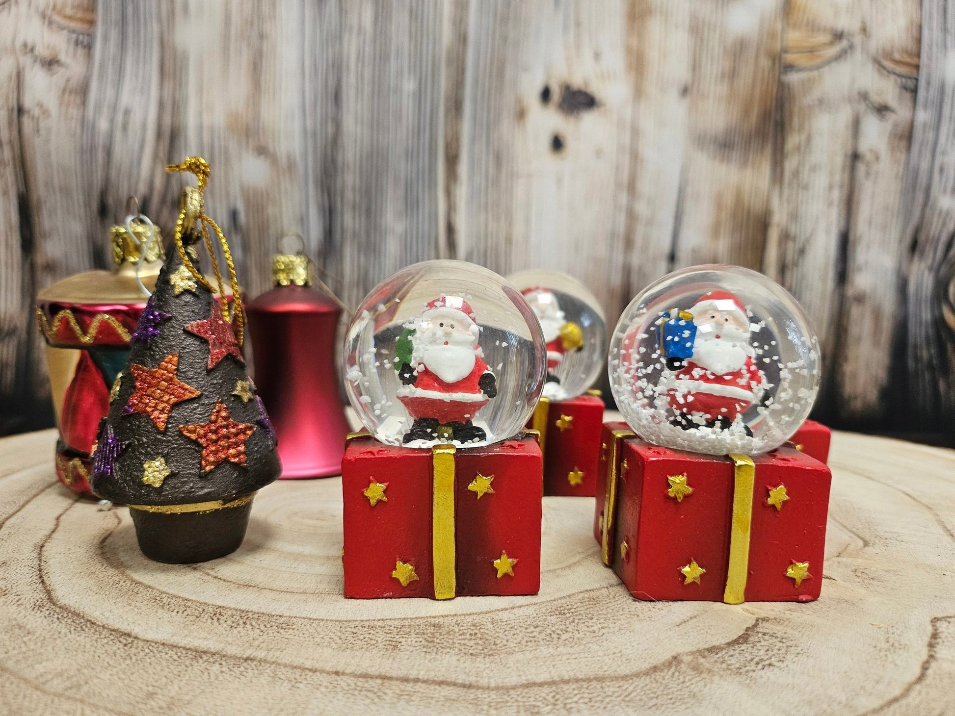 4 Süße Mini - Schneekugeln Weihnachtsmann auf Geschenke - Sockel 45mm Durchmesser - Schneekugelhaus